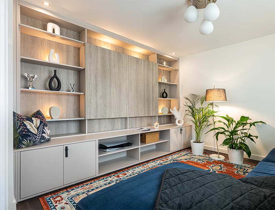 media wall concealing a tv with shelving either side