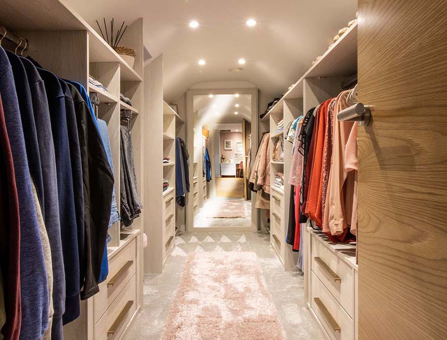 walk in wardrobe with clothes either side