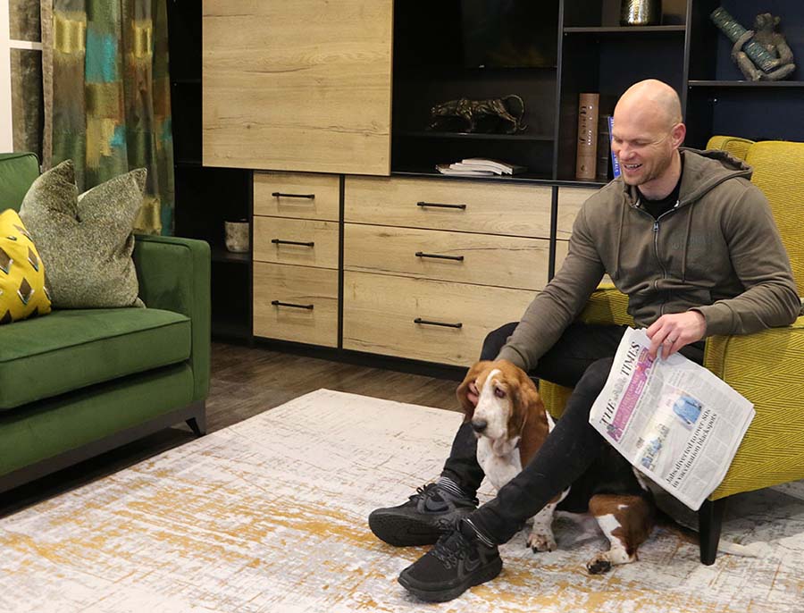 man petting a dog in living area